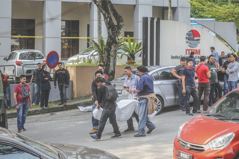 One of the bodies being carried into a police van. u00e2u20acu201d Picture by Firdaus Latif  