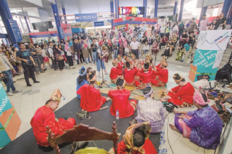 Commuters watch a cultural show, one of the many performances under the Arts on the Move initiative. 