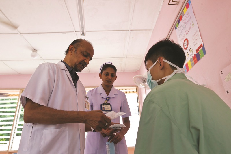 Dr Abdul Razak (left) and nurse Lalitha Gopalan check a patient at the respiratory clinic. u00e2u20acu201d Picture by Azneal Ishak 