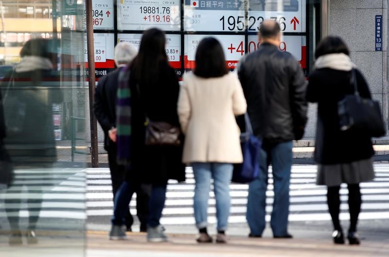 People are seen in front of an electronic board showing stock prices outside a brokerage at a business district in Tokyo, Japan, January 4, 2017. u00e2u20acu201d Reuters pic