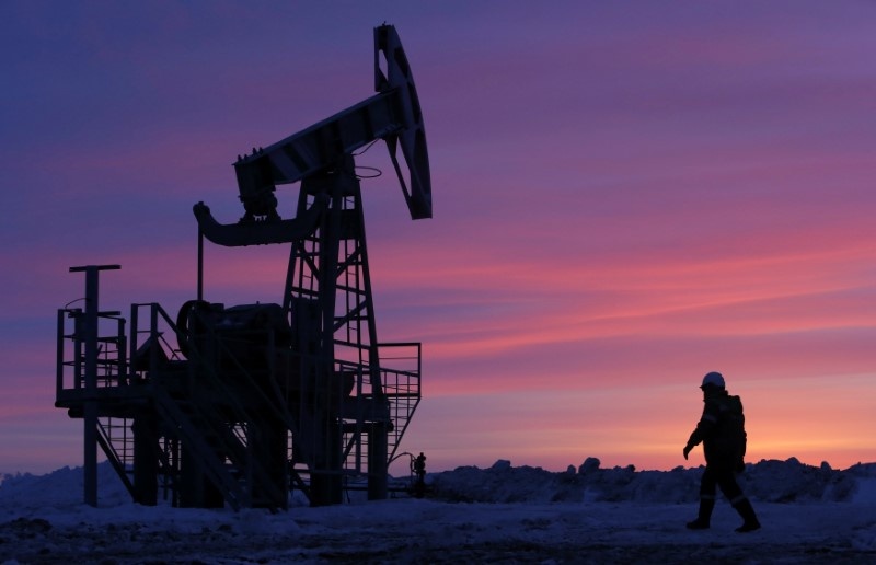 A worker walks past a pump jack on an oil field owned by the Bashneft company near Nikolo-Berezovka, Bashkortostan, Russia January 28, 2015. u00e2u20acu201d Reuters pic 