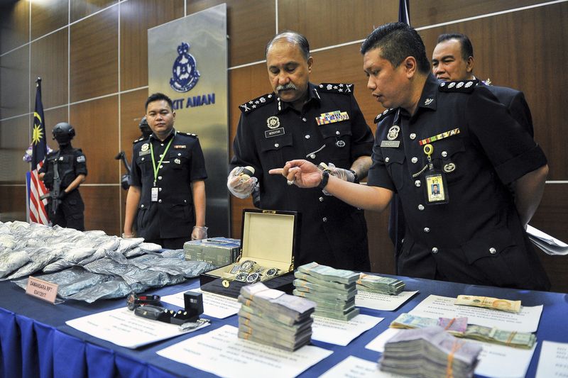 Narcotics CID director Comm Datuk Mohd Mokhtar Shariff (right) showing the drug and cash haul following the successful arrest of drug traffickers, during a press conference at police headquarters in Bukit Aman May 11, 2017. u00e2u20acu201d Bernama pic