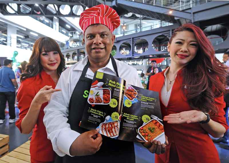 Ketua Eksekutif Kumpulan AirAsia Tan Sri Tony Fernandes menunjukkan pilihan menu makanan di dalam menu penerbangan AirAsia 'Santan' di Ibu Pejabat AirAsia Red Q, Sepang 22 Mei 2017. u00e2u20acu201d Foto Bernama