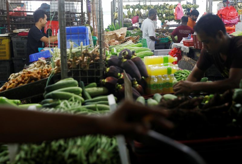 Shopkeepers arrange vegetables at a wet market in Johor Baru May 9, 2017. u00e2u20acu2022 Reuters pic