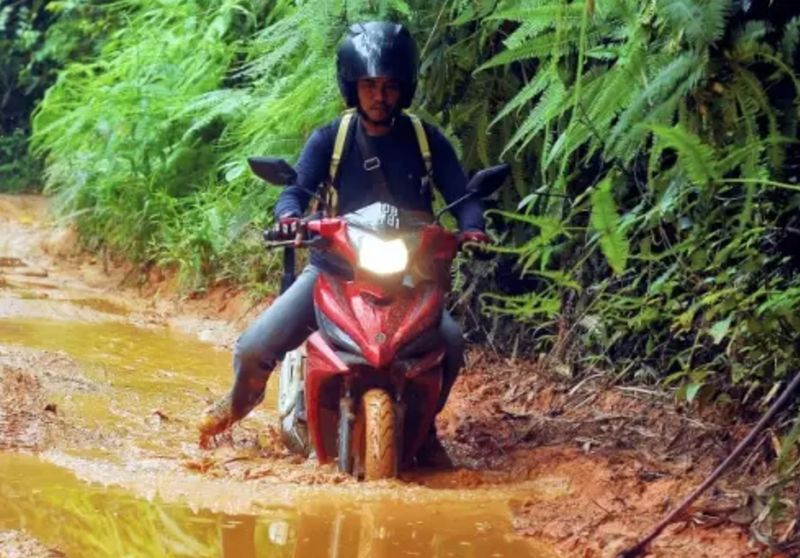 Teacher Ahmad Saidin Mohd Idris travelling through the muddy road on his u00e2u20acu02dckapcaiu00e2u20acu2122 motorcycle to reach his school among the Orang Asli settlements in Lipis, Pahang. u00e2u20acu201d  Picture courtesy of www.generosity.com
