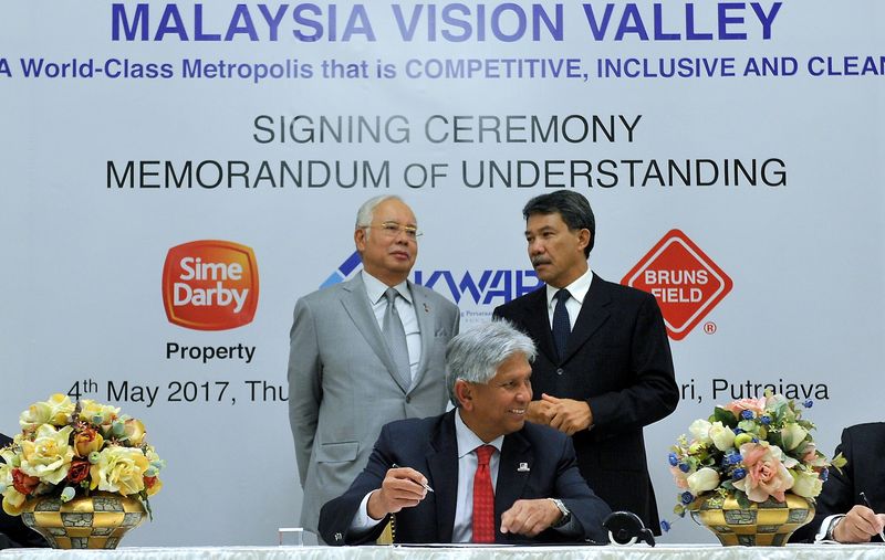 Prime Minister Datuk Seri Najib Razak (standing left) and Negri Sembilan Menteri Besar Datuk Seri Mohamad Hasan (standing right) witnessing the signing of an agreement for the development of Malaysia's Vision Valley (MVV) involving Sime Darby Property Bh