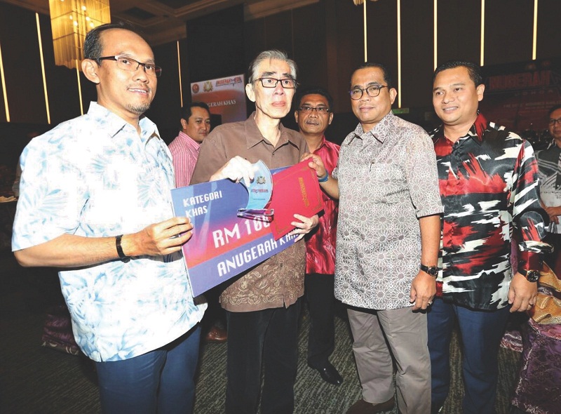 Dan receives the Anugerah Khas Media Johor 2015 from Khaled Nordin (second from right) as Johor Press Club president Fauzi Ishak (right) and Johor education committee chairman Jais Sarday look on during a ceremony on Sept 7, 2016. u00e2u20acu201d Picture by Roslan Kh