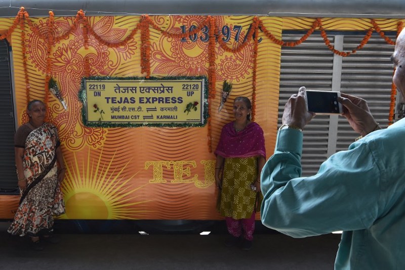 Indian passengers pose for a photograph alongside the Tejas Express luxury train during its first journey between Mumbai and Goa at Ratnagiri May 22, 2017. u00e2u20acu201d AFP pic