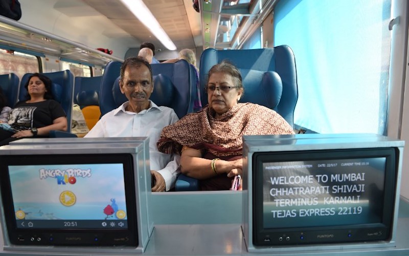 Indian passengers watch television screens on board the Tejas Express luxury train, during its first journey between Mumbai and Goa, in Mumbai May 22, 2017. — AFP pic