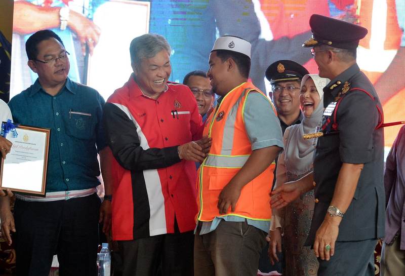 Deputy Prime Minister Datuk Seri Dr Ahmad Zahid Hamidi presenting a vest to the fire squad chief of Pondok Sekolah Menengah Agama Irshadiah Addiniah Bagan Datuk, Ustaz Aiman Rasyiddin, May 6, 2017 in Bagan Datuk. u00e2u20acu201d Bernama pic