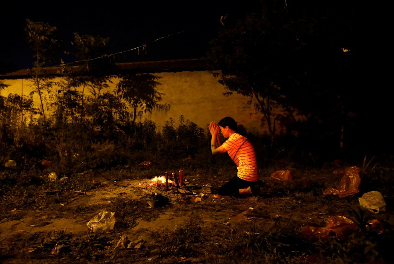 A mother prays outside Maotanchang Middle School in Maotanchang town of Luan, Anhui province, China June 3, 2017. 