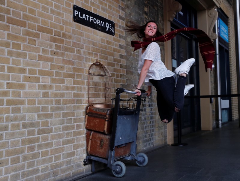 A woman poses for a photograph with the Harry Potter trolley at Kings Cross Station in London June 26, 2017. u00e2u20acu201d Reuters pic