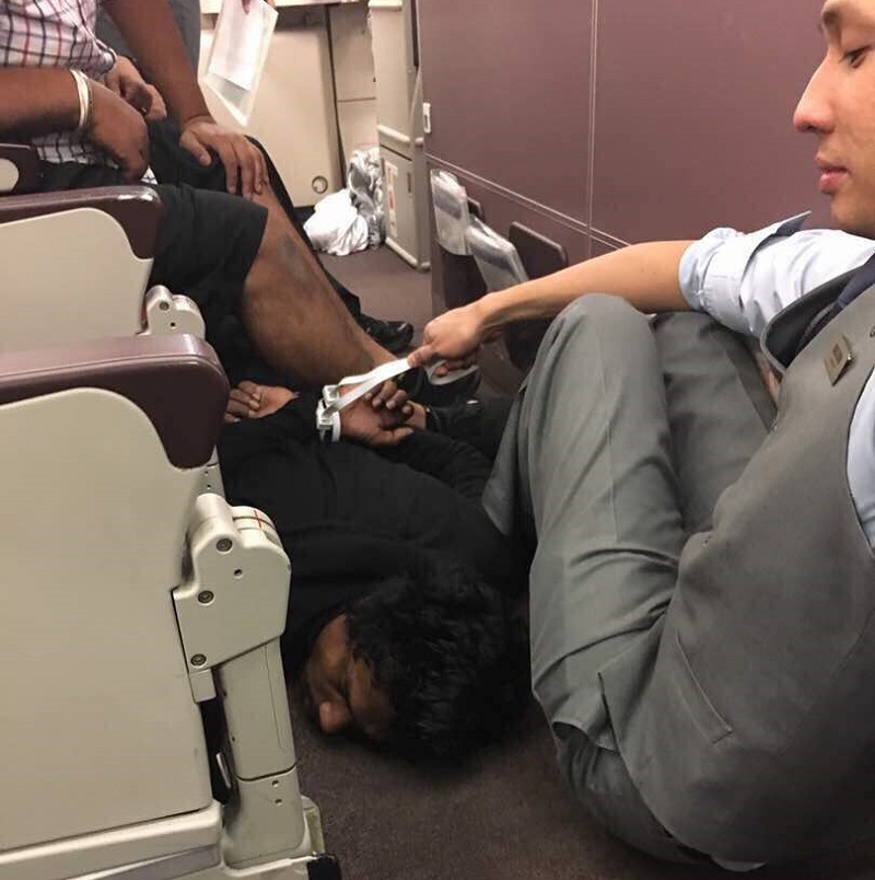 A passenger onboard the Kuala Lumpur-bound Flight MH128 (centre, in black) being subdued by fellow passengers and a crew member after he tried to enter the planeu00e2u20acu2122s cockpit. u00e2u20acu201d Picture by Jolene Teo
