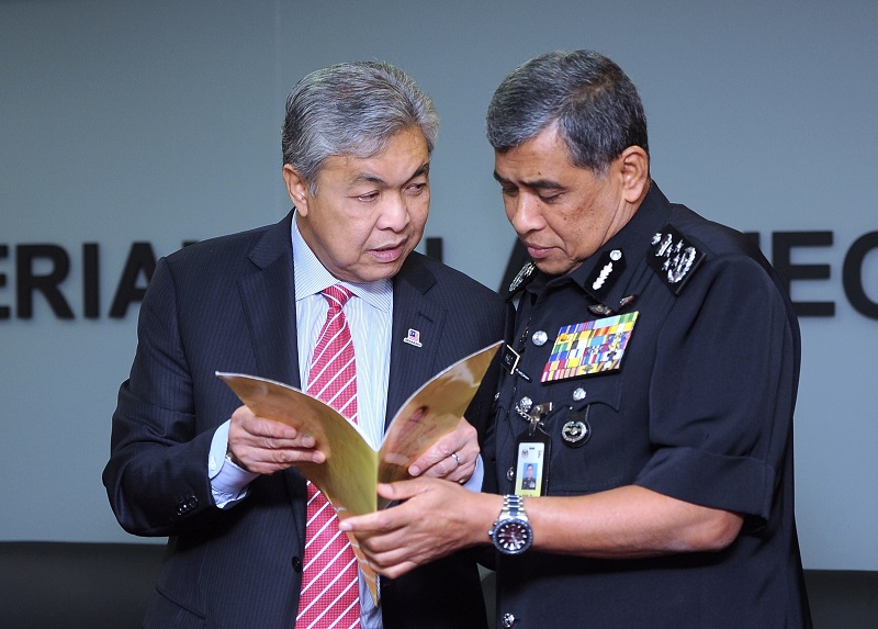 Deputy Prime Minister Datuk Seri Ahmad Zahid Hamidi (left) and Inspector-General of Police Tan Sri Khalid Abu Bakar examine a file containing a list of suspected Chinese national criminals which was handed to the Home Ministry by the Chinese government, i