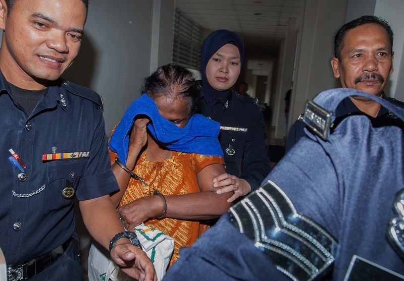 62-year-old V. Tanawali (centre) is led to the Sessions Court in Petaling Jaya June 14, 2017. u00e2u20acu201d Bernama pic