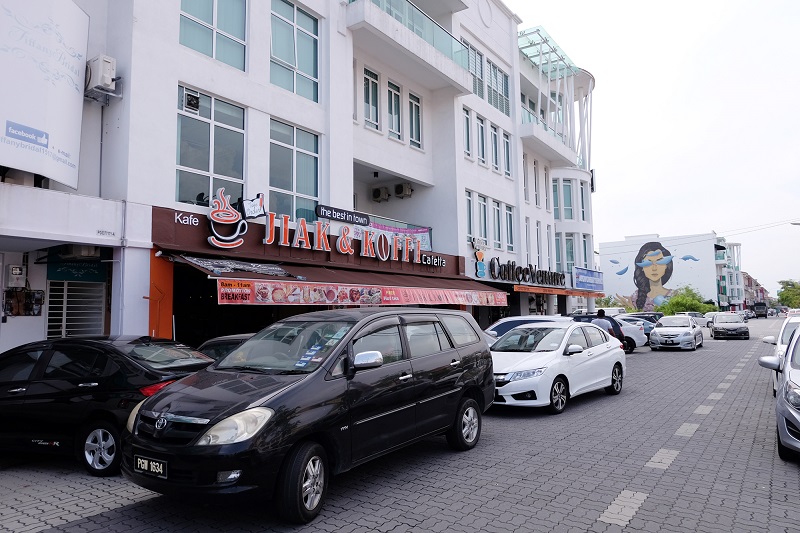 Hip and happening...cafes along Jalan Raja Uda with Sabek’s wall mural in the background. 