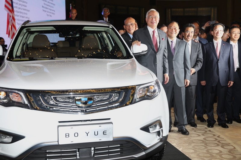 Datuk Seri Najib Razak poses next to a Geely Boyue SUV during the signing ceremony between DRB-Hicom Bhd and Zhejiang Geely Holding Group in Kuala Lumpur June 23, 2017. u00e2u20acu201d Picture by Choo Choy May