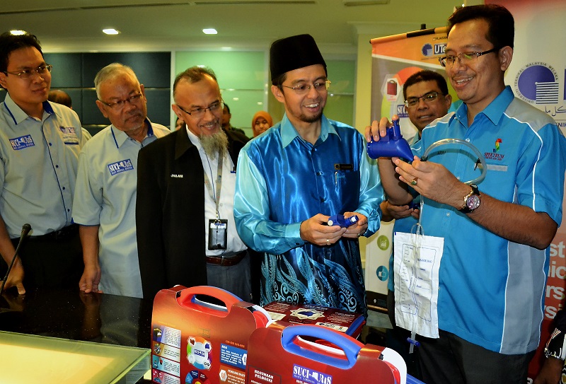 UTeM vice-chancellor Prof Datuk Shahrin Sahib (second from right) looks on as Spektrum Teknik Sdn Bhdu00e2u20acu2122s managing director Azizan Ismail (right) demonstrates the use of the u00e2u20acu02dcSuci-Urisu00e2u20acu2122 product in Melaka June 22, 2017. u00e2u20acu201d Bernama pic
