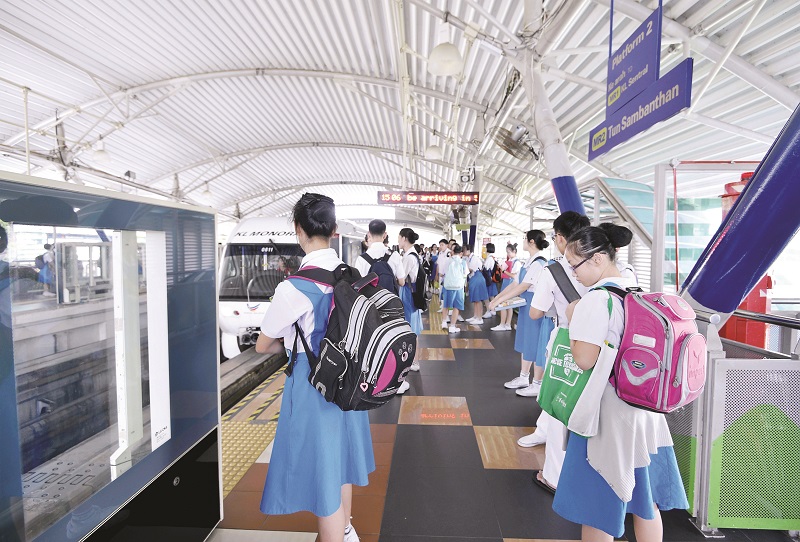 Commuters comprising mainly school children wait to board a train at the Brickfields monorail station.