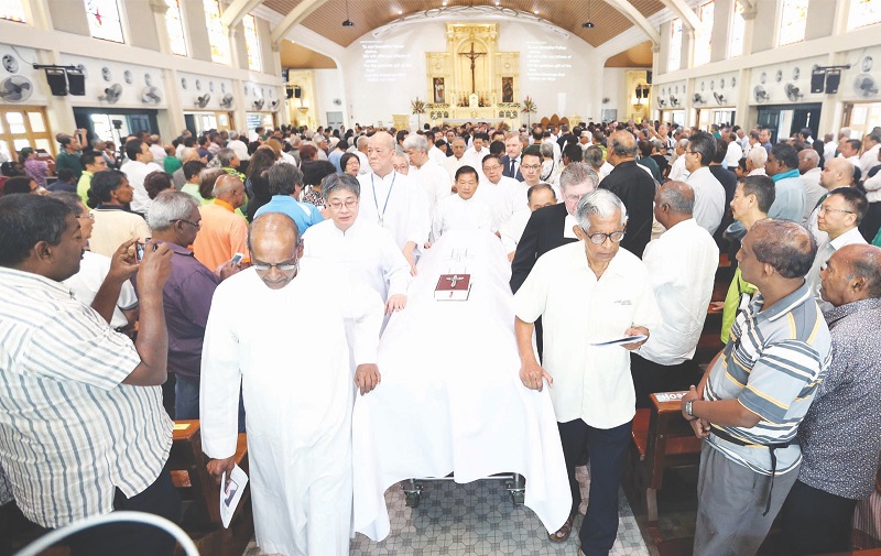 Mourners rise to pay their respects at the end of the service, as Felixu00e2u20acu2122s casket is wheeled out of the church. u00e2u20acu201d Picture by Razak Ghazali