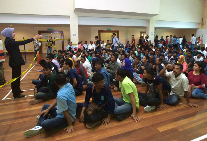 Foreign workers wait for their turn to apply for the e-card in Kuala Lumpur. u00e2u20acu2022 Bernama pic