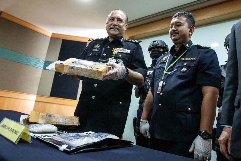 Bukit Aman Narcotics CID director Datuk Seri Mohd Mokhtar Mohd Shariff (left) showing a packet of drug seized by police, at Bukit Aman police headquarters, June 19, 2017. u00e2u20acu201d Bernama pic