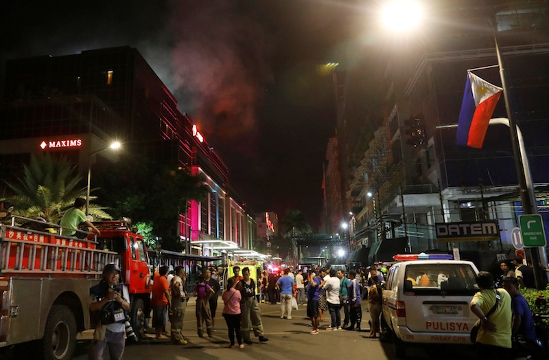 Evacuated employees and guests of hotels stand along a road and watch as smoke billows from a Resorts World building in Pasay City, Metro Manila, Philippines June 2, 2017. u00e2u20acu201d Reuters pic 