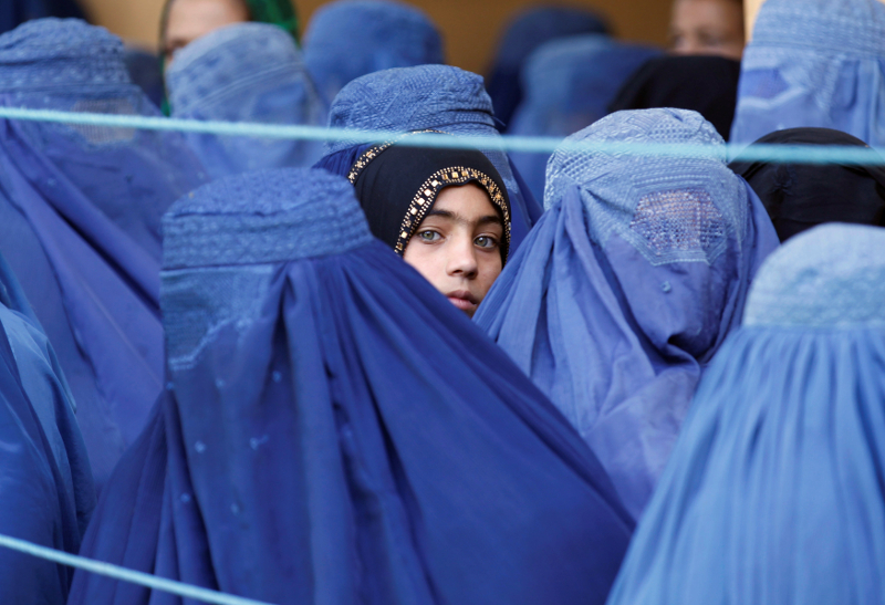 A girl looks on among Afghan women lining up to receive relief assistance, during the holy month of Ramadan in Jalalabad June 11, 2017. u00e2u20acu201d Reuters pic