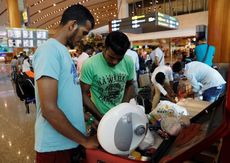 Hussein (left), a Bangladeshi worker who said he lost his job and has to return home, packs his luggage at Changi Airport in Singapore March 28, 2017. u00e2u20acu201d Reuters pic