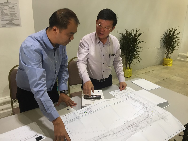 State exco Chow Kon Yeow (right) with SRS Consortium project manager Julian Yap looking at the EIA report for the LRT project in George Town July 21, 2017. u00e2u20acu201d Picture by Opalyn Mok