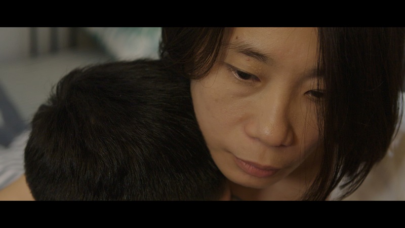 Cheng Chau Yang is seen hugging her son, both are Malaysians who cannot visit their home country because of a travel ban in China. u00e2u20acu201d Screen capture via YouTube/Myra Cheng