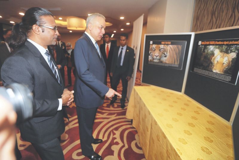 Sultan of Perak, Sultan Nazrin Muizzuddin Shah visits an exhibition held after a high-level dialogue on enhancing efforts on protecting the Malayan tiger. With him is WWF-Malaysia executive director Datuk Dr Dionysius SK Sharma. u00e2u20acu201d Picture by Farhan Naji