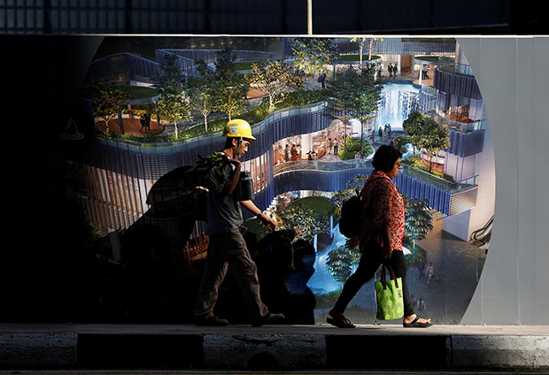 A construction worker — very likely a foreigner — walks past a construction site in Singapore. — Reuters pic