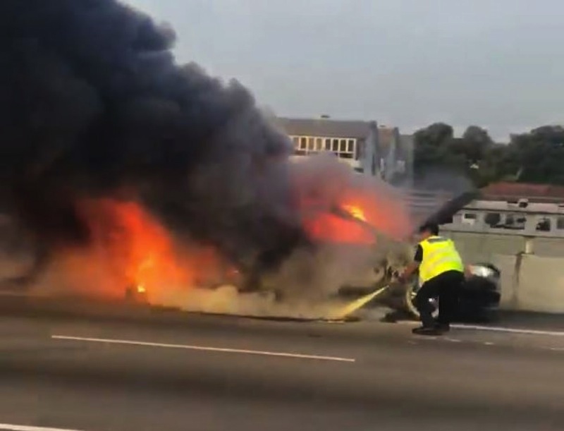 A screengrab from a video shows a personnel fighting the flames after a car caught fire along the CTE. u00e2u20acu201d Picture by Huang Yiting's Facebook page