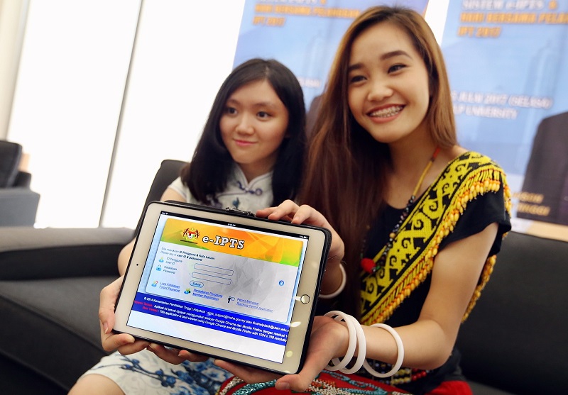 HELP University students Ng Suet Cheng, 18 (left), and Larissa Ping Liew, 18, showcasing the new e-IPTS system that was launched at the HELP University Subang Campus. u00e2u20acu201d Picture by Zuraneeza Zulkifli