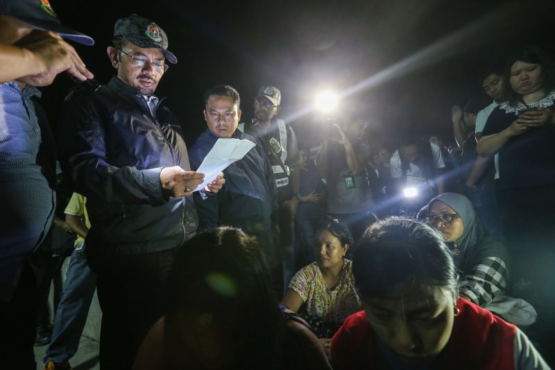 Mustafar checks a list of workers during a raid at Kawasan Perkilang Batu 8 in Klang after E-Kad application deadline expired at midnight on Friday. u00e2u20acu201d Picture by Ahmad Zamzahuri