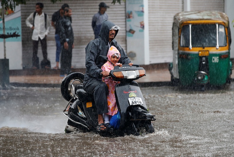 A man drives through a flooded road with his child after heavy rains in Ahmedabad, India, July 18, 2017. u00e2u20acu201d Reuters pic 