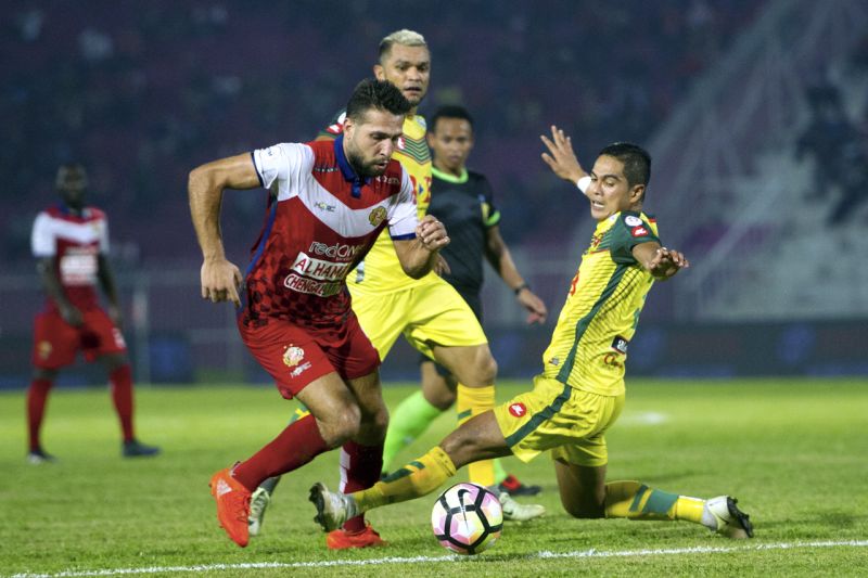 Kelantan player Abou Bakra Al Mel (left) is challenged by Kedah players during the Group C match at the Sultan Muhammad IV Stadium in Kota Baru last night. u00e2u20acu2022 Bernama pic