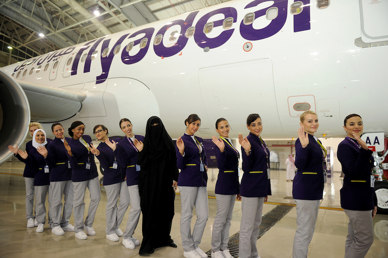 Asian Sadaf Khan (centre), the designer of the flight attendant uniforms, poses for a picture with cabin crew of the new Flyadeal company during the launch ceremony. u00e2u20acu201d AFP pic