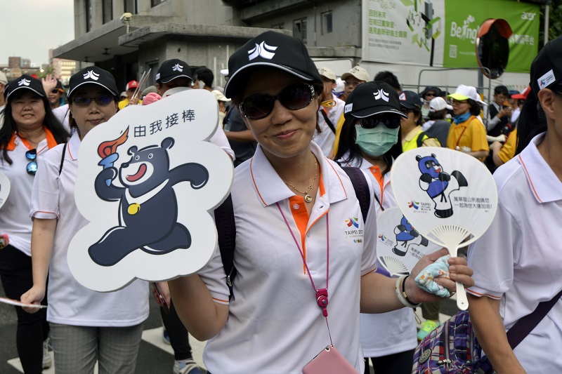This picture taken on August 12, 2017 shows a woman displaying products with the image of the Formosan Black Bear, mascot of the Summer Universiade, during a parade to celebrate the upcoming sporting event in Taipei. u00e2u20acu201d Reuters pic