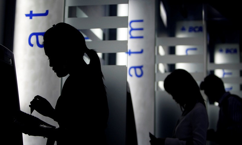 FILE PHOTO: Customers use Bank Central Asia (BCA) automatic teller machines at BCA's headquarters in Jakarta, Indonesia February 3, 2010. REUTERS/Beawiharta/File Photo