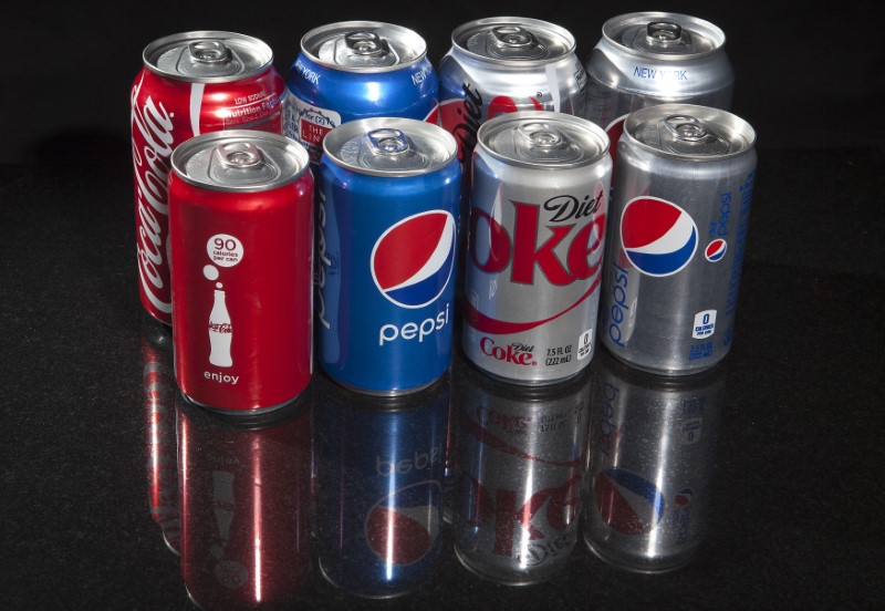 Regular and mini cans of Coke and Pepsi are pictured in this photo illustration in New York. u00e2u20acu201d Reuters pic