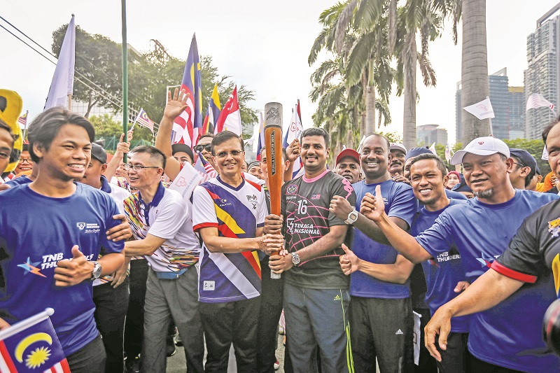 Former Federal Territories minister Datuk Seri Raja Nong Chik Raja Zainal Abidin hands Kumar the torch. Kaliswaran is third from right, and Nor Saiful, right. u00e2u20acu201d Picture by Firdaus Latif