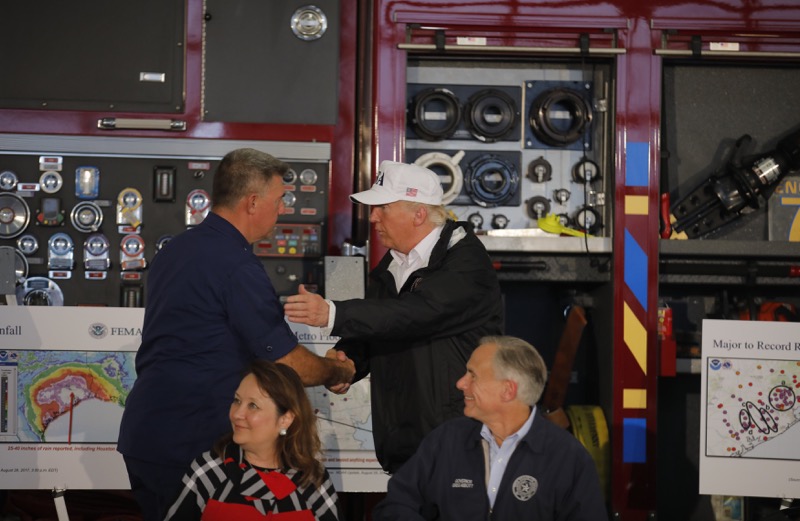 US President Donald Trump (centre) greets a firefighter at Fire Station 5 while receiving a briefing with Texas Governor Greg Abbott (right) on Tropical Storm Harvey relief efforts with Texas Governor Greg Abbott in Corpus Christi, Texas August 29, 2017.  — Reuters pic