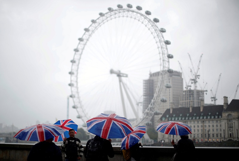 Tourists carrying Union Flag umbrellas shelter from the rain in front of the London Eye wheel in London August 9, 2017. u00e2u20acu201d Reuters pic
