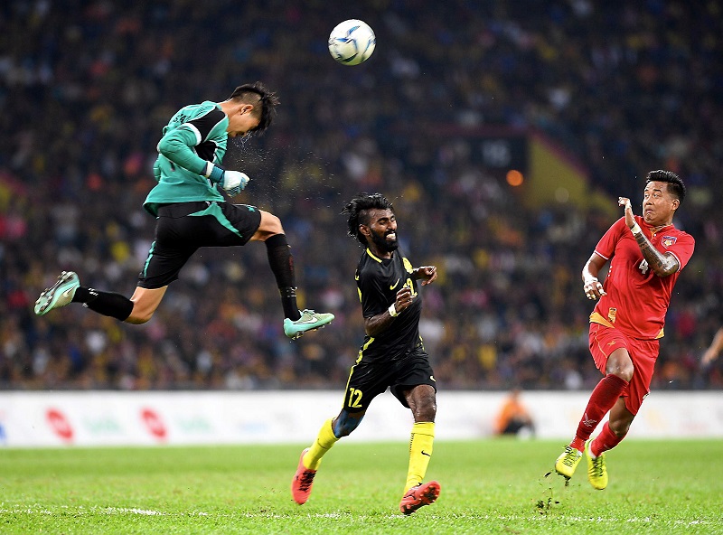 Penyerang negara, N Thanabalan (tengah) cuba merampas bola dari penjaga gol Myanmar, Sann Sat (kiri) pada perlawanan di Stadium Shah Alam, malam tadi. u00e2u20acu201d Foto Bernama