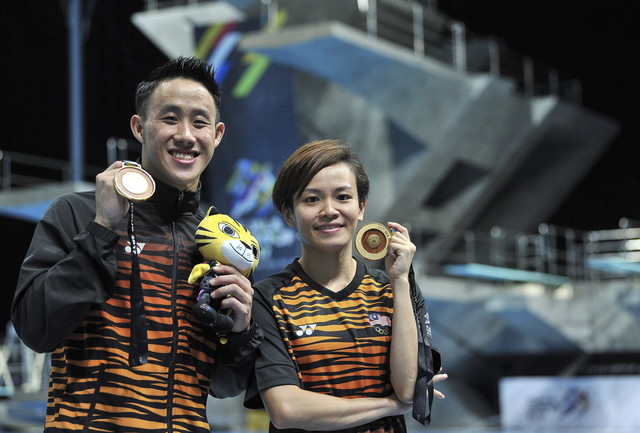 Malaysia's divers Ooi Tze Liang (left) and Cheong Jun Hoong (right) show off their gold medals after winning the 10M Men Platform and 1M Springboard finals respectively during the 29th SEA Games at National Aquatic Centre in Bukit Jalil today. u00e2u20acu201d Bernama