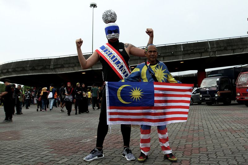 A Malaysia and a Thailand supporter posing for a photo during the 29th SEA Games football final at the Shah Alam Stadium, August 29, 2017. u00e2u20acu201d Picture by Miera Zulyana