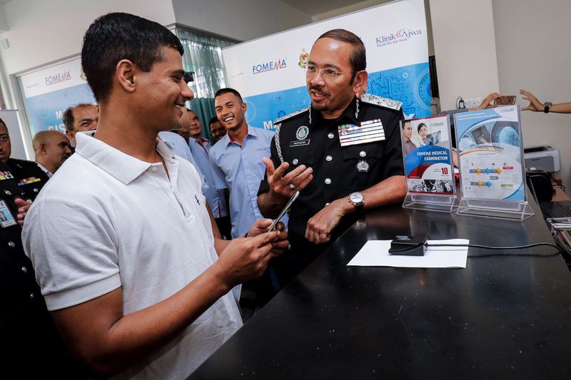 Director-General of Immigration Department Datuk Seri Mustafar Ali (right) talking to Nepalese foreign worker Khadka Deepak about the fingerprint identification tool at Ajwa Clinic, Shah Alam August 1, 2017. u00e2u20acu201d Bernama pic