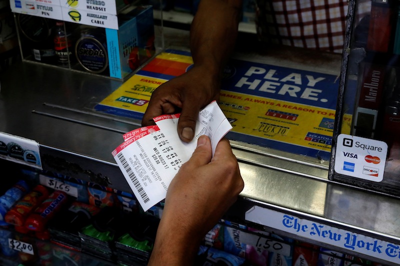 A customer purchases Powerball lottery tickets for a US$700 million jackpot at a newsstand in New York City, August 23, 2017. u00e2u20acu201d Reuters pic